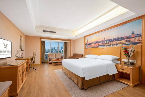 武汉维也纳酒店武汉解放大道店的卧室配有一张白色大床和一张书桌