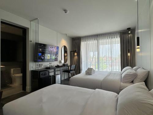 清迈POR Singharat的酒店客房设有两张床和电视。