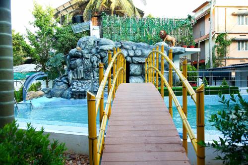 库玛拉孔Lake Palace Family Resort Kumarakom的水上公园,设有通往游泳池的木制走道