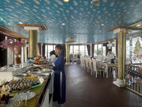 下龙湾Halong AQUAR CRUISE的妇女在餐厅参加自助餐