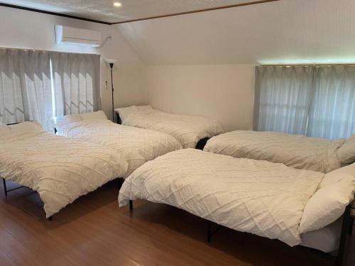 鸣门市AYA-Naruto的配有白色床单的客房内的三张床