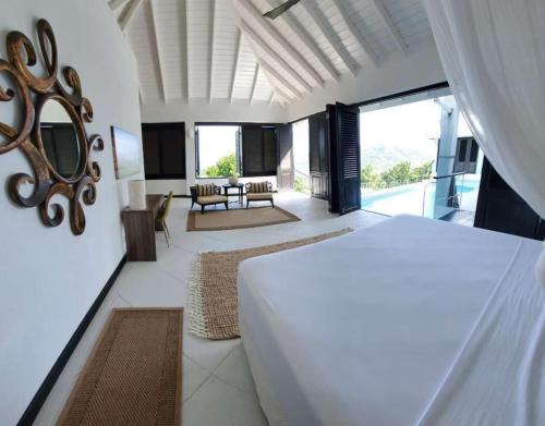BequiaLux Villa w/ Stunning Panoramic Ocean Views的一间卧室设有一张床和一间客厅。
