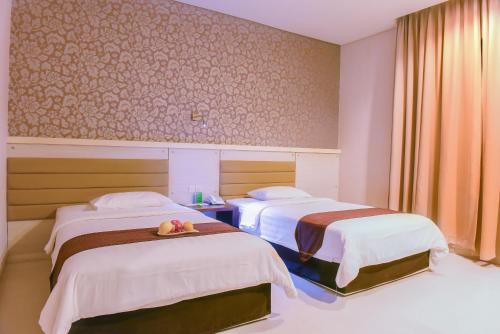 古邦Sahid T-More Hotel的酒店客房,配有两张带水果盘的床