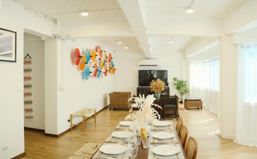 曼谷Private Full-Floor Spacious 5BR in China Town的一间长餐厅,配有白色的桌子和椅子