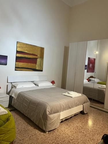 TrepuzziSalento b&b Trepuzzi的卧室配有一张床,墙上挂有绘画作品