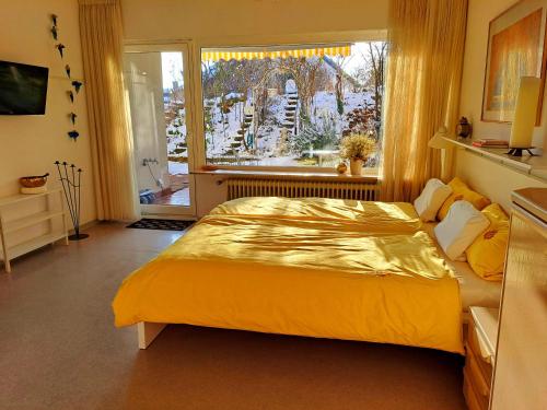 葡萄酒之路上的诺伊施塔特Wohlfühl & Wellness Oase的一间卧室设有一张黄色的大床和一扇窗户。