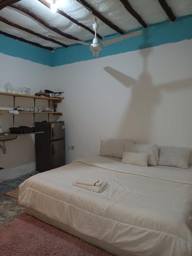 乌昆达Moha Airbnb Diani的卧室配有一张大白色床,墙上有阴影