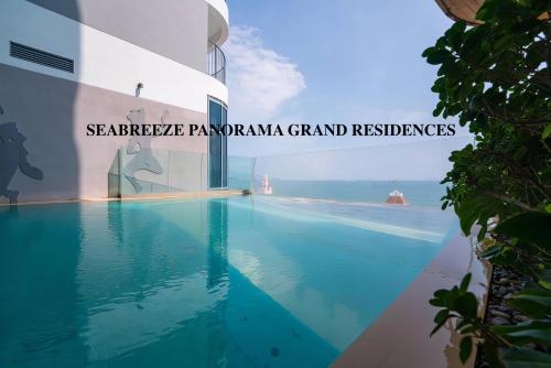 芽庄SeaBreeze Panorama Grand Residences的一座建筑物边的游泳池,上面有“铁甲”字样
