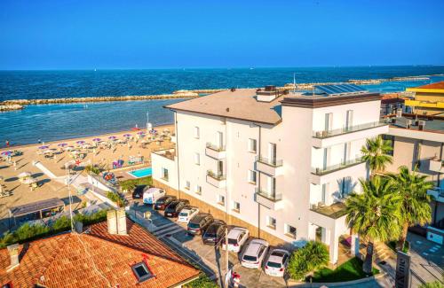 里米尼You & Me Beach Hotel的享有大楼和海滩的空中景致
