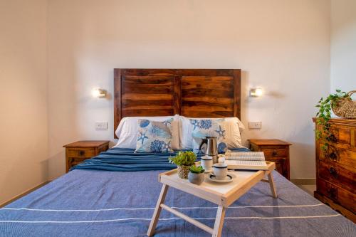 圣特奥多罗Luxury House San Teodoro Center的一间卧室配有一张带木制床头板和一张桌子的床。