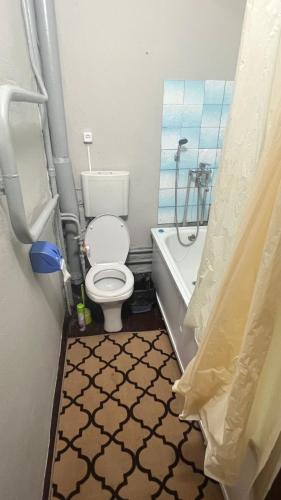 塔拉兹Чистая и уютная квартира в 6-ом микрорайоне的一间带卫生间、浴缸和淋浴的浴室