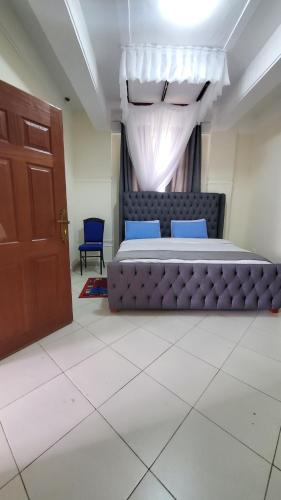基塔莱Le-voyage Resort Kitale的一间卧室设有一张大床和一扇门
