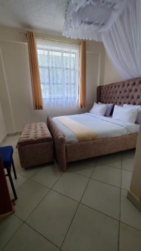 基塔莱Le-voyage Resort Kitale的一间卧室设有一张大床和一个窗户。
