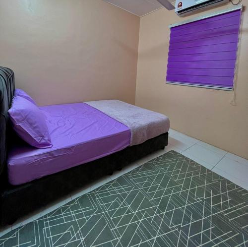 安顺Nuha's Homestay Teluk Intan的一间小卧室,配有紫色的床和窗户