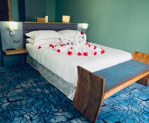KigoAquarius Kigo Resort的一张大床,上面有红玫瑰