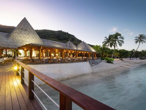 MaharepaSofitel Kia Ora Moorea Beach Resort的一座带游泳池的度假村,位于一座建筑前