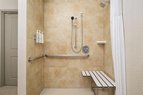埃尔帕索埃尔帕索机场希尔顿花园酒店的浴室内配有淋浴和长凳