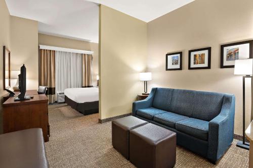 Saint RoseComfort Inn New Orleans Airport South的酒店客房配有蓝色的沙发和床。