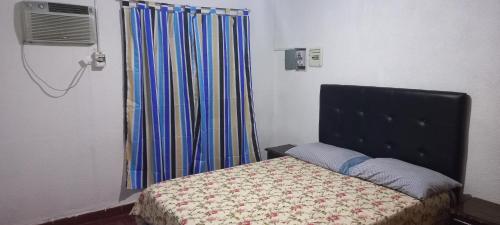 拉里奥哈Hause la rioja的一间卧室配有床和带窗帘的窗户