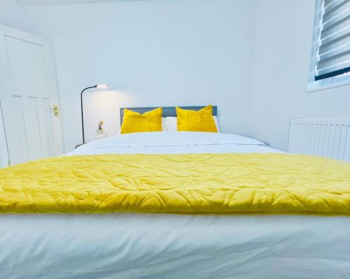 珀弗利特Ensuite Luxury Bedroom In Purfleet的一张带黄色棉被和黄色枕头的床
