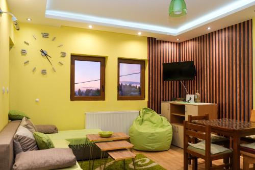 科帕奥尼克Vila Čajetinski biser-Apartment Classic的客厅配有沙发和墙上的时钟