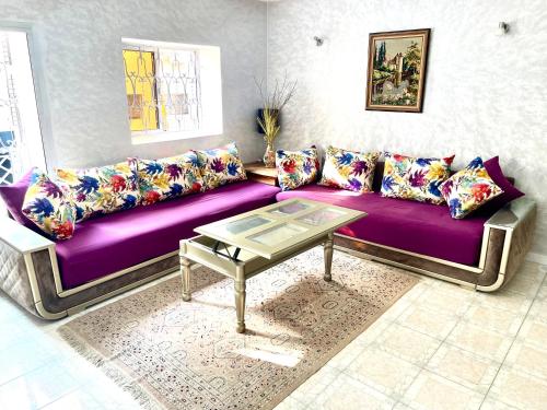 非斯Appartement centre-ville avec Wifi Fibre Optique的客厅配有一张紫色沙发,配有一张桌子