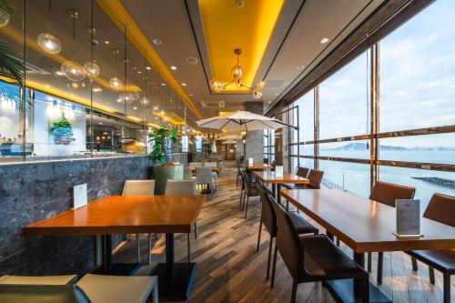 仁川市Inchon sky and sea ocean view hotel的餐厅设有桌椅和大窗户。