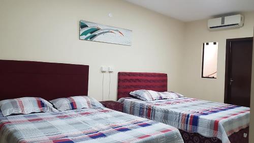 埃斯特城España Confort 2的两张睡床彼此相邻,位于一个房间里