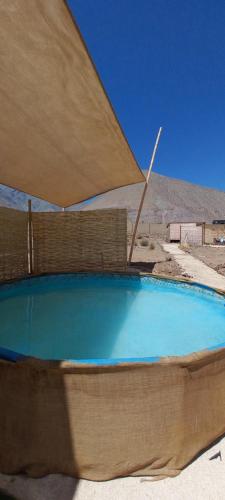 维库尼亚Campo de Cielo Mamalluca Valle de Elqui的一个带大遮阳伞的大型游泳池