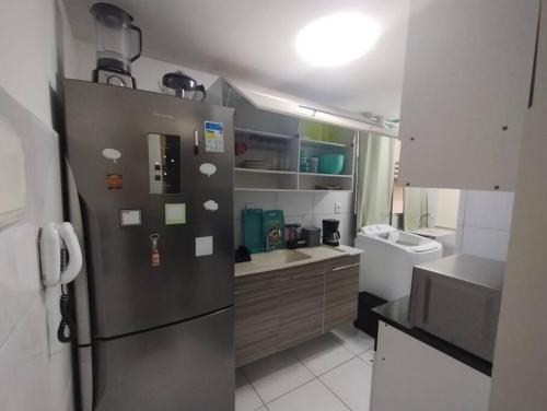 伊波茹卡Cantinho da Ju的厨房配有不锈钢冰箱和水槽