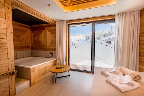 图拉彻霍赫Alpin Peaks的一间带浴缸的桑拿浴室以及一张带毛巾的桌子