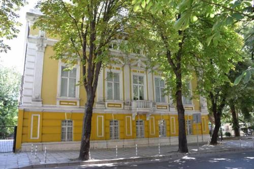 瓦尔纳Primorski Apartment的前面有树木的黄色建筑