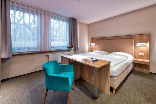 格拉尔-米里茨杜奈海景酒店的酒店客房配有一张床、一张桌子和一张蓝色椅子