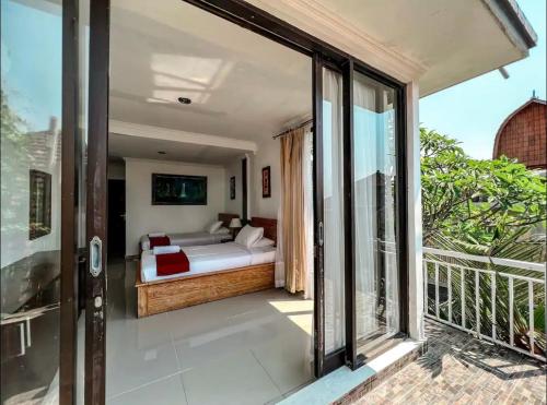 KetewelGriya Umadui Bali的阳台卧室(带一张床)