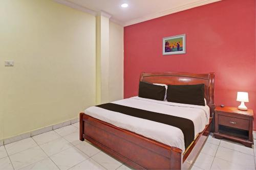 海得拉巴Hotel Ruma Near Nampally Railway Station的一间卧室设有一张床和红色的墙壁