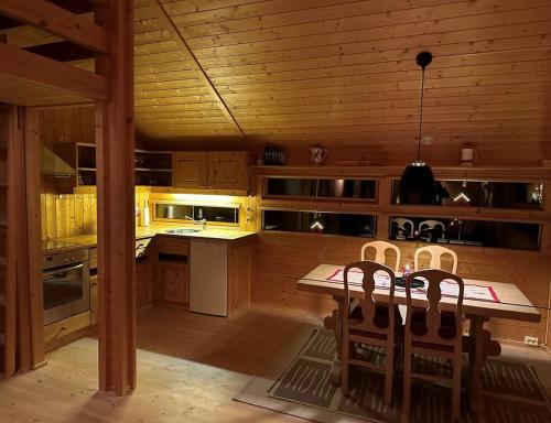 HoloKinnkosen - cabin with panoramic view for 6 persons的厨房配有木制橱柜和桌椅