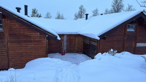 HoloKinnkosen - cabin with panoramic view for 6 persons的屋顶上积雪覆盖的车库