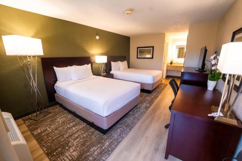 奥兰多Mai Hana Hotel的酒店客房配有两张床和一张书桌