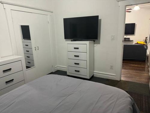 PassaicNYC Gateway: Cozy Home with Easy Access的一间卧室配有一张床和一台平面电视