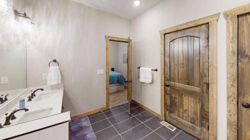 布兰森Luxury Lake Resort Lodge的一间带水槽和木门的浴室