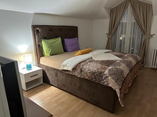 尼克希奇JS APARTMAN的一间卧室配有一张带色彩缤纷枕头的大床