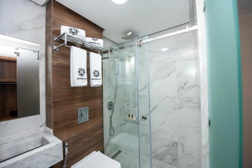 纳祖尔MAGNIFIQUE HOTEL的浴室设有玻璃淋浴间和卫生间