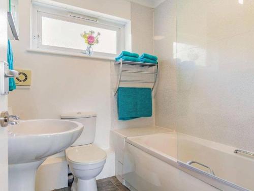 托基Lovely Magnolia Accommodation 3king Torquay的白色的浴室设有水槽、卫生间和窗户。