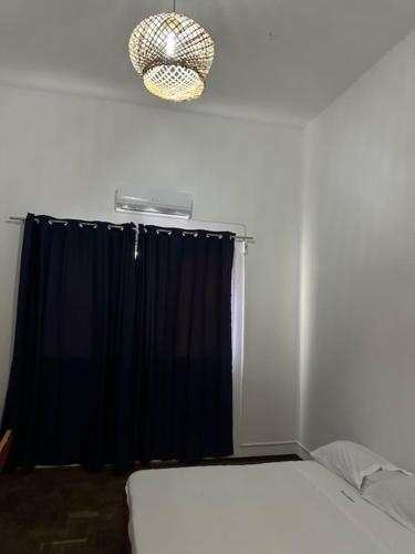 Pousada de Namacurra的一间卧室配有床和黑色窗帘