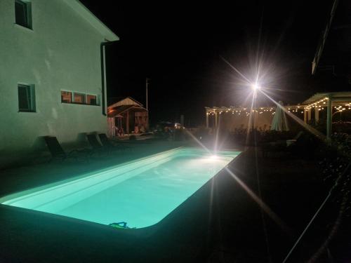 科斯蒂内什蒂Maison du golf的夜间游泳池,有街灯