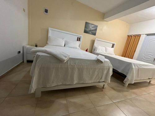 Azua de CompostelaHabitación doble Villa Marchena Azua的一间卧室配有两张带白色床单的床