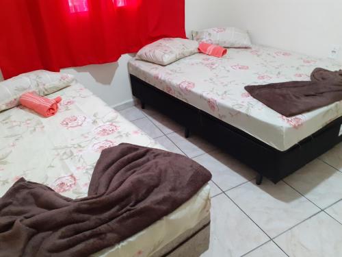 阿帕雷西达Espaço matteo的红色窗帘间内的两张单人床