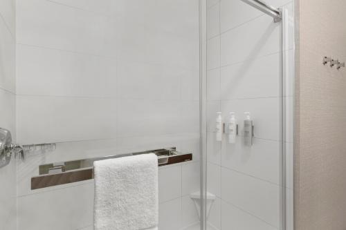 康沃尔Hampton Inn By Hilton Cornwall的带淋浴的浴室和玻璃门