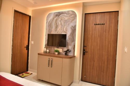 斋浦尔Hotel Shree Krishna的一间设有门的房间和墙上的电视