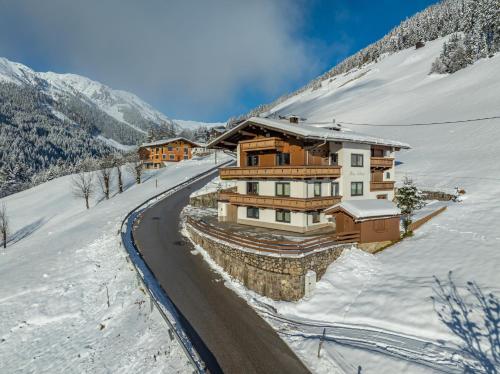 希帕赫舒若酒店的一座有道路的雪覆盖的山丘上的房子